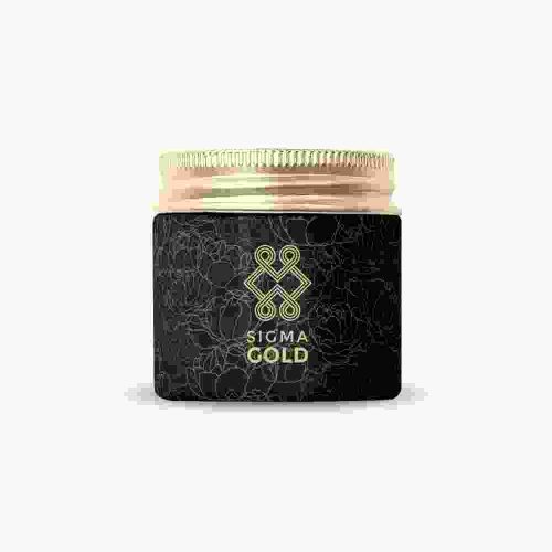 A black jar of gold colored cosmetic product.