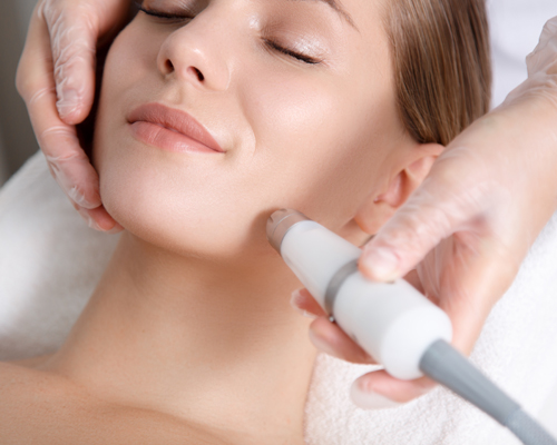 A woman getting her face waxed with an electric device.