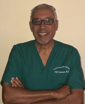 A man in green scrubs standing with his arms crossed.
