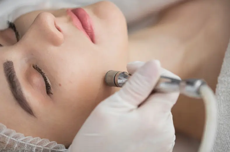 A woman receiving a microdermabrasion treatment.